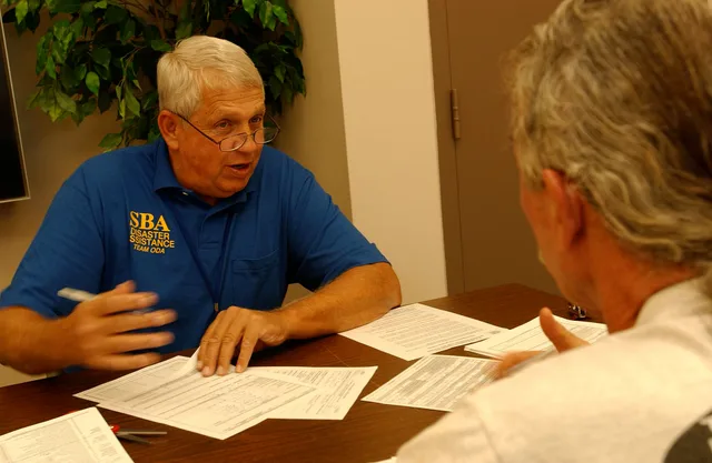 Findlay, Ohio, September 12, 2007 -- Larry Bates (L) Small Business Administration (SBA) representative speaks with a local business owner who suffered damage to his business during recent flooding. SBA set up a registration desk at a local bank in Findlay to help business owners in the town. John F. First 100 days mistakes: reflexes to avoid in a slow month